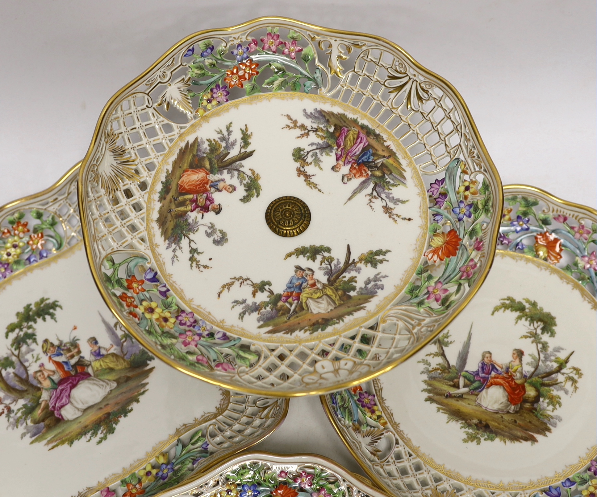 A Dresden Meissen style part dessert set, painted with courting couples in the landscape, consisting of a comport two dishes and four plates, comport 15.5cm high